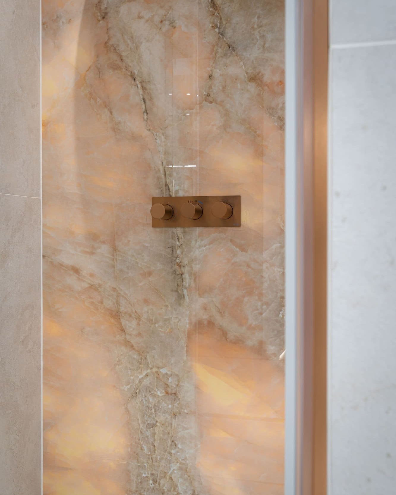Bateria prysznicowa MOBI Copper Brushed na tle bursztynowej płytki Emil Ceramica.
